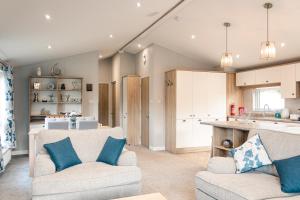uma sala de estar com dois sofás e uma cozinha em Lilac Lodge with Hot Tub em York