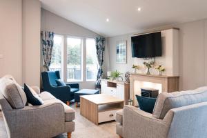 a living room with two chairs and a tv at Lilac Lodge with Hot Tub in York