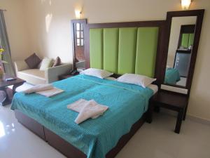 a bedroom with a large bed with two towels on it at Riverside Regency Resort in Baga