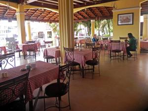 un restaurant avec des tables et des chaises et des personnes qui y sont assises dans l'établissement Riverside Regency Resort, à Baga