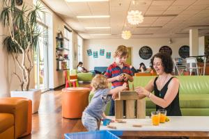 a woman and a child playing with a wooden toy at YHA Adelaide Central in Adelaide