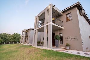 un gran edificio con un patio de césped delante de él en Altissimo Guesthouse, en Bloemfontein