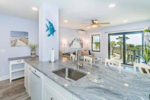 uma cozinha com um lavatório e uma sala de estar em Direct Oceanfront Villa - Heated Pool & Breathtaking Ocean View em Hilton Head Island
