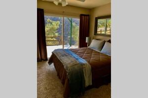 a bedroom with a bed and a large window at Stunning Views Total Privacy Absolute Tranquility in Wofford Heights