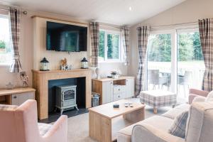 a living room with a fireplace and a tv at Kinship Lodge with Hot Tub in York