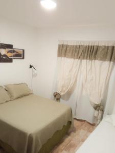 1 dormitorio con 2 camas y ventana en Departamentos Pachamama en Tunuyán