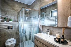 a bathroom with a sink and a glass shower at Dione Villa in Kókkinos Pírgos +13 photos