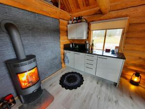 a kitchen with a fireplace in a log cabin at Jürivärava Saunamaja in Kantsi