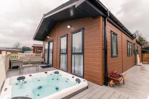 約克的住宿－Lakeside View Lodge with Hot Tub，一座小房子,甲板上设有热水浴缸