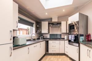 uma cozinha com armários brancos e uma clarabóia em Lakeside View Lodge with Hot Tub em York