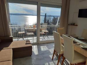 a living room with a table and a view of the water at Apartment Elena in Dramalj