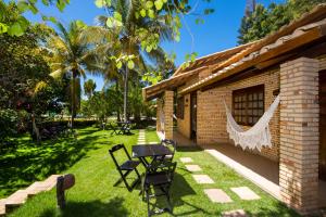 a patio of a house with a table and chairs at Hotel Chale Lagoa Dos Ingas in Martins