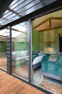 a glass house with a bedroom and a bed at ZEN-bungalow NO 1 met sauna en hottub in Rheezerveen