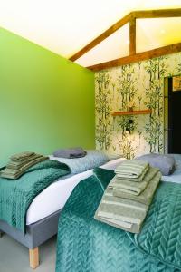 two beds in a room with green walls at ZEN-bungalow NO 1 met sauna en hottub in Rheezerveen