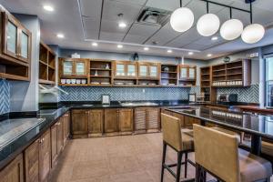 a large kitchen with wooden cabinets and a bar at Hyatt Place Fort Worth / Cityview in Fort Worth