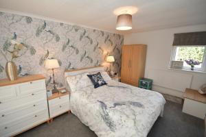 um quarto com uma cama com papel de parede de peixe em Hare Lodge em Woodhall Spa
