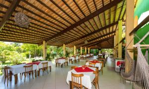 a restaurant with tables and chairs and a wooden ceiling at Hotel Chale Lagoa Dos Ingas in Martins
