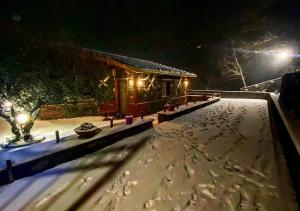 una casa cubierta de nieve por la noche con luces en Casa Monte Etna en Maletto