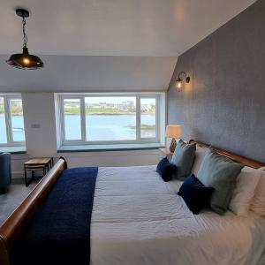 um quarto com uma cama grande e uma janela grande em The Steam Packet inn em Isle of Whithorn