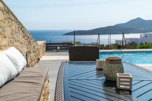 a blue table with chairs and a swimming pool at Villa Tani in Agios Georgios