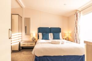 a bedroom with a large bed with blue accents at The Crucible lodge with Hot Tub in York