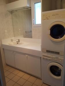ein Badezimmer mit einem Waschbecken und einer Waschmaschine in der Unterkunft Le Cézembre - vue 180 baie St Malo in Saint-Malo