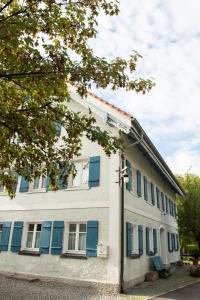 a white building with blue shutters on it at Weberswohnung - KEINE Monteure in Amtzell