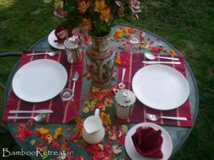 a table with two white plates and a vase with flowers at Bamboo Retreat in Gangtok