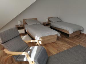 a attic room with two beds and a couch at Serce Puszczy Wiartel in Wiartel