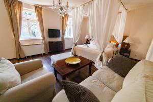 sala de estar con 2 camas y sofá en Lounge Apartments, en Cracovia