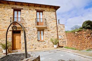 una casa de piedra con una puerta delante de ella en Casa El Habanero II en Destriana