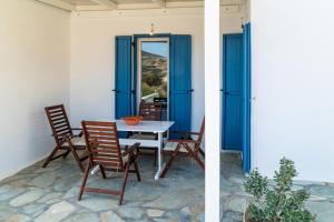 a dining room with blue doors and a table and chairs at Villa Tani in Agios Georgios