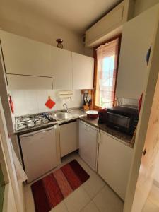 a small kitchen with white cabinets and a sink at Casa Ameria in Cecina