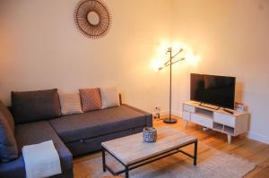 un soggiorno con divano e TV di POISSY Appartements COSY a Poissy