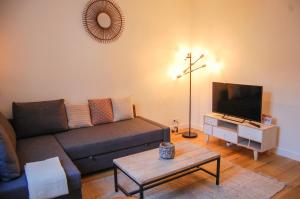 a living room with a couch and a tv at POISSY Appartements COSY in Poissy