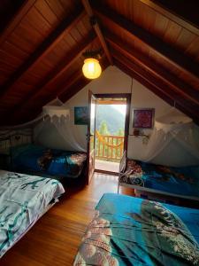 a attic room with two beds and a window at Rivendell Centro de Arte y Retiro in El Paso