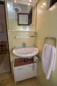 een badkamer met een wastafel en een spiegel bij Studio in Mali Losinj 36584 in Mali Lošinj +9 foto's