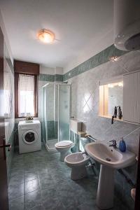 Un baño con lavabo, inodoro y ducha. en Apartment in Rosolina Mare 25085, en Rosolina Mare 12 fotos más