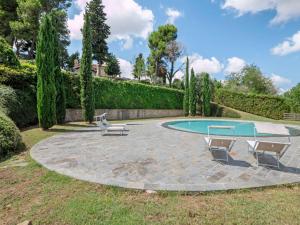a patio with two chairs and a pool at Apartment in Villagrande with Pool & Garden in Mombaroccio +18 photos
