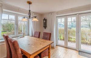 comedor con mesa, sillas y ventanas en Lovely Home In Langenhorn With House A Panoramic View, en Langenhorn