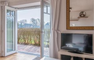 sala de estar con TV y puerta corredera de cristal en Lovely Home In Langenhorn With House A Panoramic View, en Langenhorn