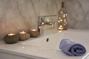 a bathroom sink with candles and a towel and a faucet at Selce Holiday in Selce +37 photos