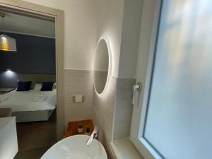 a bathroom with a sink and a mirror and a bed at Relais Petruzzelli in Bari