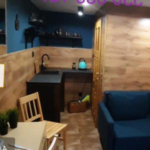 Pokoj z antresolą في هيلمونو: مطبخ مع حوض وطاولة وكرسي أزرق