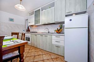 Štanga的住宿－Apartment in Rovinj with Two-Bedrooms 5，厨房配有白色橱柜和白色冰箱。