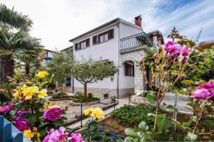 Biały dom z kwiatami przed nim w obiekcie Apartment in Rovinj/Istrien 11562 w mieście Štanga