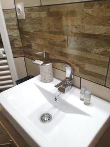 a white sink in a bathroom with a mirror at L'Imprévu in Bourisp