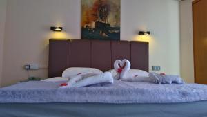 una cama con dos cisnes hechos de toallas en Sunway Hotel, en Alanya