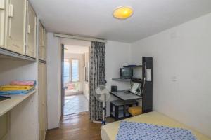 Cette chambre comprend un lit et un bureau avec un four micro-ondes. dans l'établissement Apartments Mira - economy, à Igrane