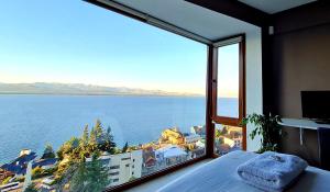 Dormitorio con ventana grande con vistas al agua en Lake View Bariloche en San Carlos de Bariloche